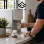 Seorang lelaki sedang mengisi air ke dalam gelas menggunakan penapis air di dapur moden dengan botol Episor diletakkan di atas countertop sebagai sebahagian rutin harian.