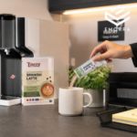 Seseorang sedang membancuh Enera Spanish Latte di pantry pejabat moden sebagai sebahagian daripada rutin harian yang praktikal.